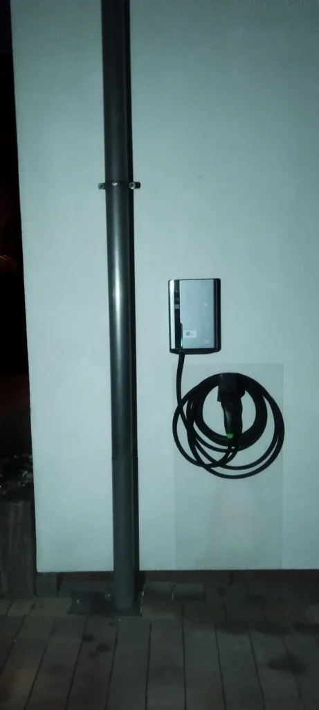 Ładowarka samochodu elektrycznego (wallbox) na ścianie budynku z kablem Type 2