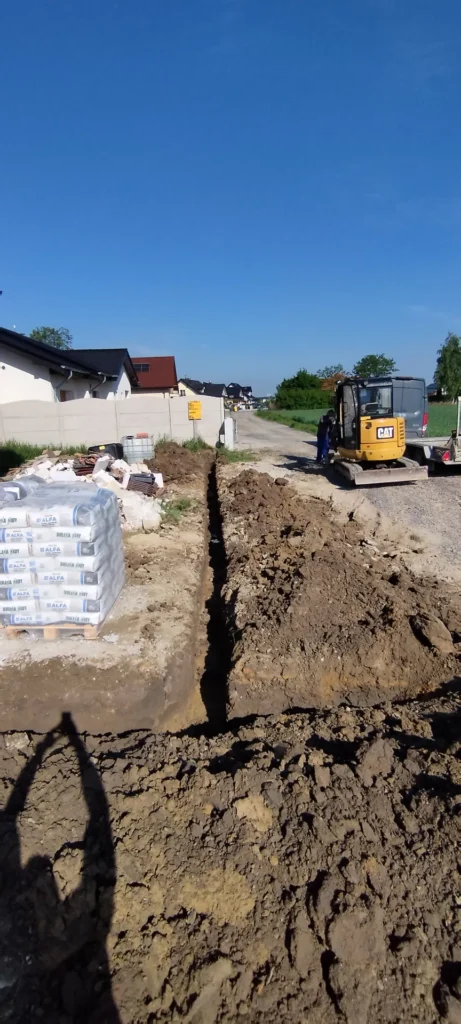 Wykop liniowy pod przyłącze prowadzony do drogi, koparka